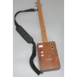 Folk art design wooden three string American guitar with rectangular body. (B.P. 21% + VAT)