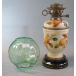 Early 20th Century double oil burner lamp having green glass globular shade, above a ceramic