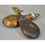 Copper and brass repousse powder flask, together with another brass and leather powder flask. (2) (