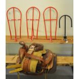 Spanish leather horse saddle together with three metal hanging saddle racks and another similar. (