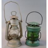 Two vintage tin and glass single oil burners, one marked 'Made in China'. (2) (B.P. 21% + VAT)
