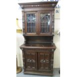 Late 19th century oak Flemish design ornately carved two stage stained and leaded glass cabinet