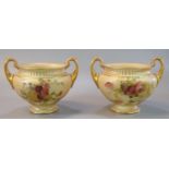 Pair of Royal Worcester blush ivory urn shaped two handled vases of baluster form, hand painted with