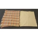 Two vintage Welsh woollen blankets: one plain cream and the other a peach ground check blanket or