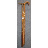 Three bamboo walking sticks/canes, one with horn handle, together with a swagger stick/baton with