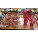 Tray of cranberry glass items: six small dimpled glass tumblers and six Italian 'Lubiana' glasses