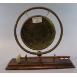 20th century brass framed dinner gong on rectangular wooded base, with striker. 20cm diameter
