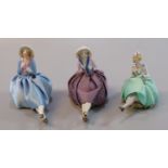 Three continental porcelain pin cushion dolls. (3) (B.P. 21% + VAT)