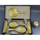 Silver yellow guilloche enamel cased dressing table set comprising: four brushes and a hand