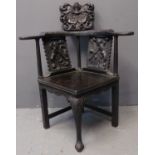 18th century oak corner chair, later carved and embellished with figural panels, foliate carving and