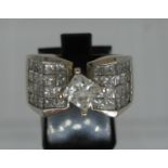 14ct white gold diamond ring set in Modernist style. The central princess cut diamond flanked by