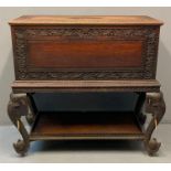 Indian ornately carved hardwood chest on stand, the moulded and ornately carved top with central