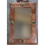 Made for Liberty & Co, London, an Arts & Crafts copper framed mirror, overall decorated with four