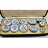 A set of enamel buttons with floral painted decoration. Comprising eight buttons, on smaller and a