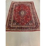 Vintage red ground Persian Mashad carpet with traditional floral medallion design. 276x192cm approx.