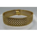 18ct gold wide bracelet with integral clasp and two safety clasps. Length 7.75 inches (18cm)