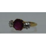 A synthetic ruby and diamond three stone ring. Ring size L & 1/2. Approx weight 3.8 grams. (B.P. 21%