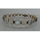 A graduated moonstone bracelet set in yellow metal. Approx weight 10.9 grams. (B.P. 21% + VAT)