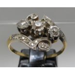 Three stone diamond ring with scrolling design. Ring size P. Approx weight 3.5 grams. (B.P. 21% +