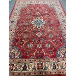 Terracotta ground Persian Sarouk carpet with traditional floral medallion design. 334x225cm