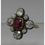 Victorian ruby and diamond ring. The ruby set in silver and surrounded by old cut diamonds on a