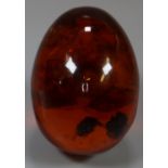 Amber and plastic egg. (B.P. 21% + VAT)