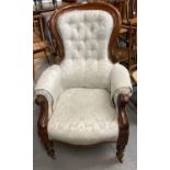 Victorian walnut button back show frame fireside armchair on baluster turned legs and castors. (B.P.