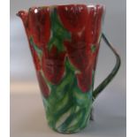 Modern Art pottery single handled jug of tapering form, overall decorated with tulips. 31cm high