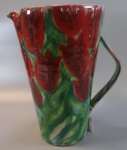 Modern Art pottery single handled jug of tapering form, overall decorated with tulips. 31cm high