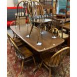 Mid century elm refectory dining table together with a set of eight elm Ercol hoop, spindle and