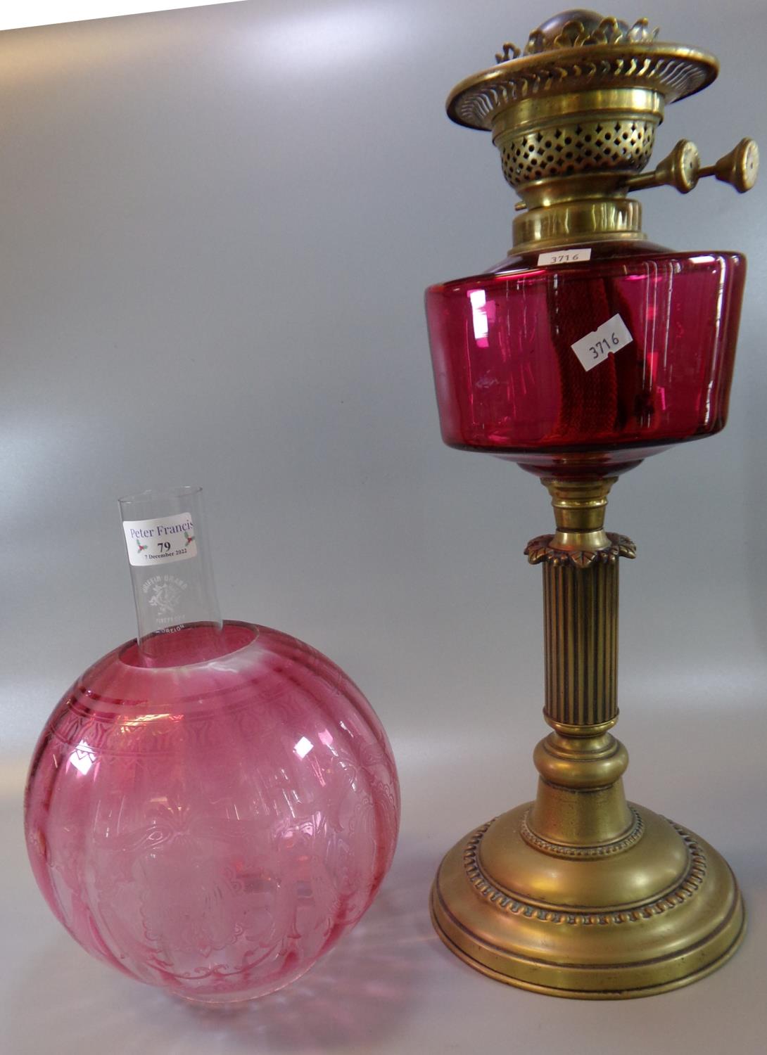 Early 20th Century double oil burner lamp, having cranberry glass etched globular shade, above a