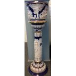 Italian ceramic blue and white jardiniere on stand, overall with moulded decoration of mythical