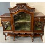 Edwardian mahogany display cabinet, overall ornately carved and having three glass doors. The