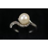 Platinum and pearl dress ring with diamond chips. 6g approx. Ring size I. (B.P. 21% + VAT)