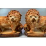 Pair of early 20th Century Staffordshire pottery fireside lions with glass eyes, standing on