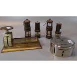 Four miniature miners lamps, together with a midland Bank money box and table top postal scales with