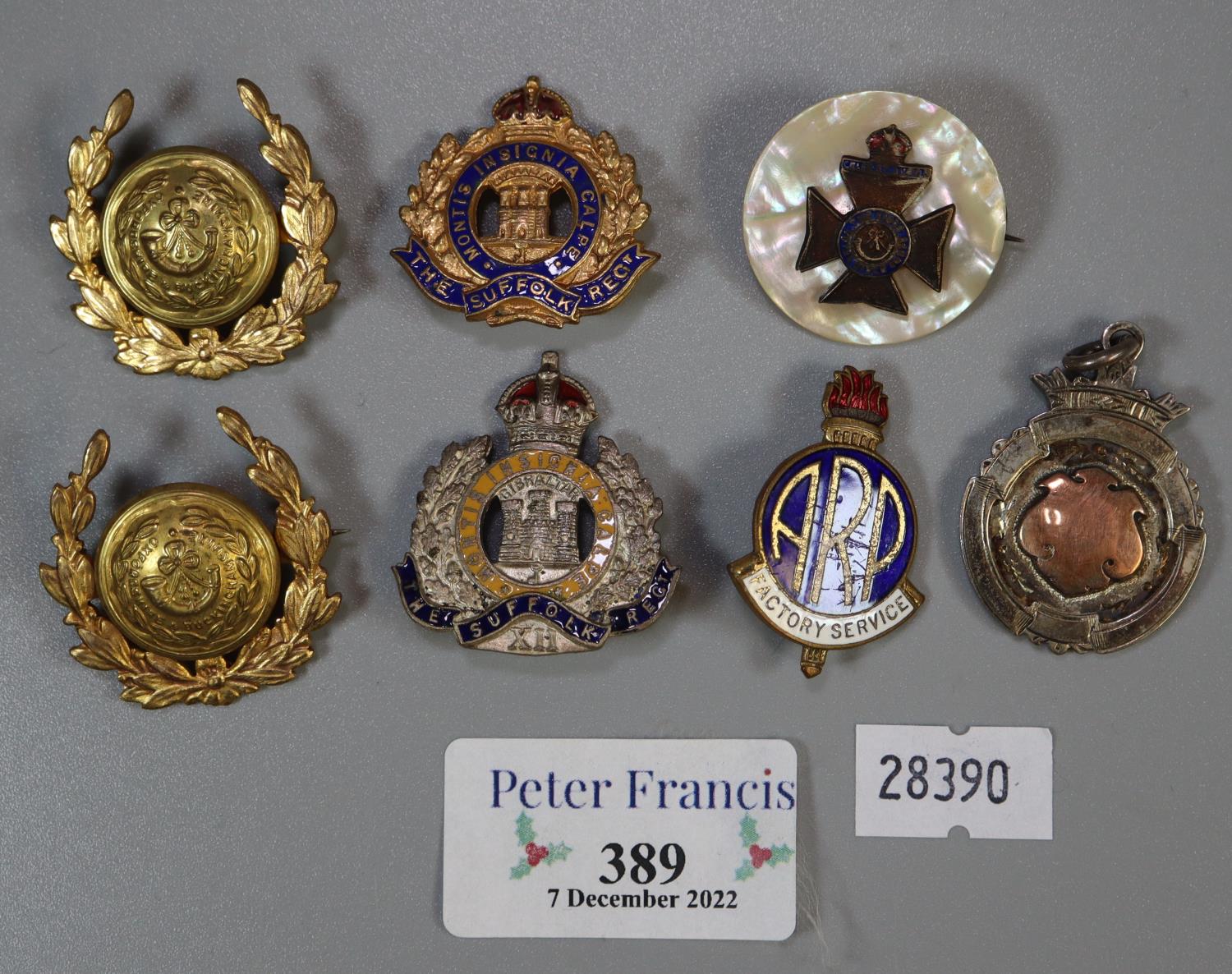 Small collection of military pin badges and fobs etc. To include; The Suffolk Regiment and