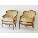 A pair of Louis XV style carved walnut, corbeille bergeres