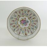 A hand decorated reticulated white porcelain bowl