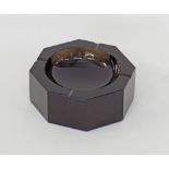 An octagonal burgundy crystal ashtray