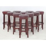 A set of ten stained wood and burgundy leather, round bar stools