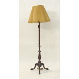 A carved and stained wood floor lamp