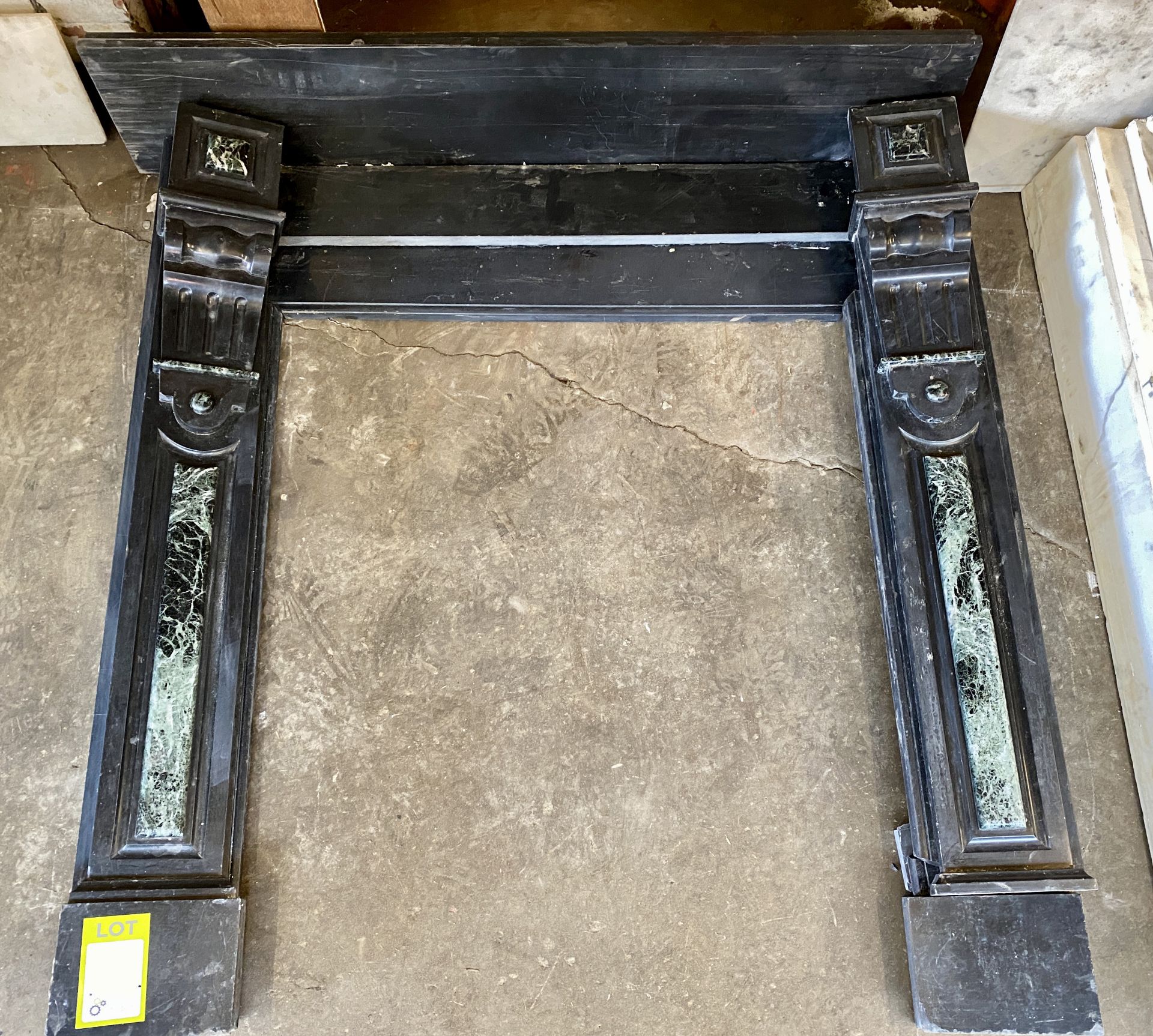 A carved black marble Fireplace, with Verdigris marble decoration, circa 1900s, 47in wide x 47in