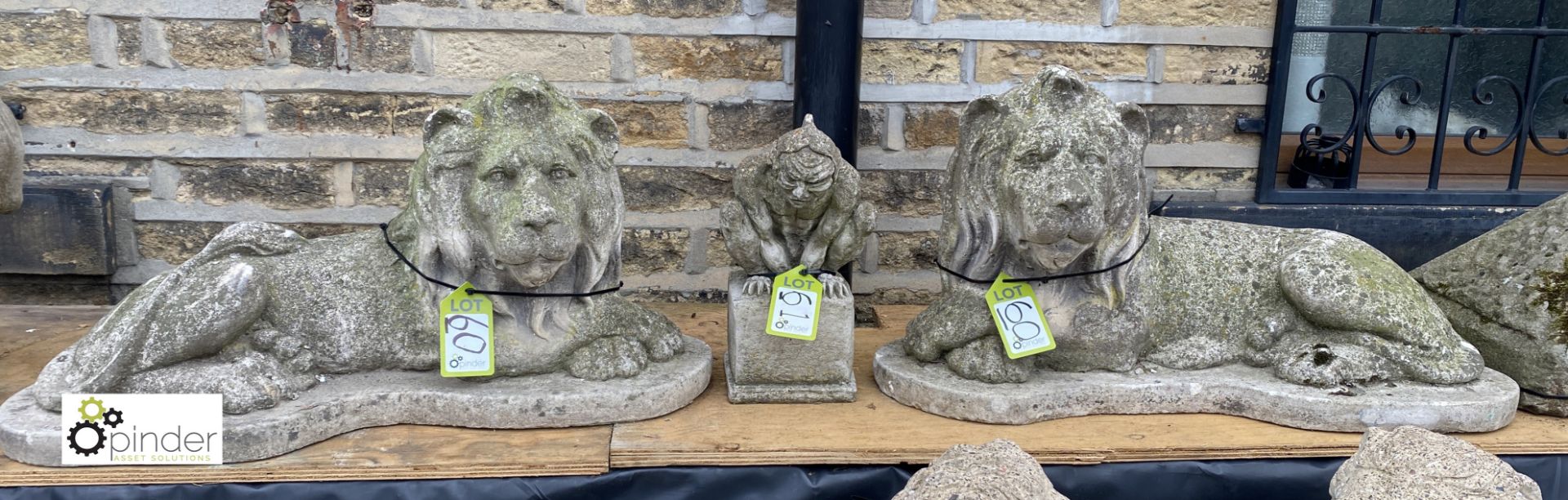 A pair reconstituted recumbent Statue of Lions, on plinths, 18in high x 34in wide