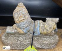 A reconstituted stone Statue of Gnome reading Lazy Days book laying down, 8in high x 12in long