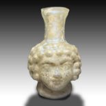 A ROMAN GLASS DOUBLE EROS HEAD FLASK Circa 3rd Century A.D. Or Later