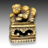 AN IVORY NETSUKE OF A KARAKO, MEIJI PERIOD