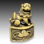 AN IVORY NETSUKE OF A SHI SHI DOG, MEIJI PERIOD