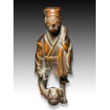 A WOOD NETSUKE OF A MAN CATCHING ONI, MEIJI PERIOD