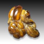 A CHINESE AMBER MELON SHAPED BUDDHA HAND FIGURE, QING DYNASTY (1644-1911)